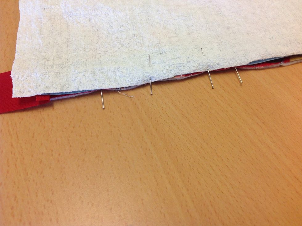 L\u00e4gg sedan fodertyget ovanp\u00e5 och n\u00e5la fast det ocks\u00e5. Sy fast med raks\u00f6m, anv\u00e4nd pressarfot f\u00f6r dragkedja. Var f\u00f6rsiktig s\u00e5 att du inte syr i dragkedjan! G\u00f6r sedan likadant p\u00e5 andra sidan.