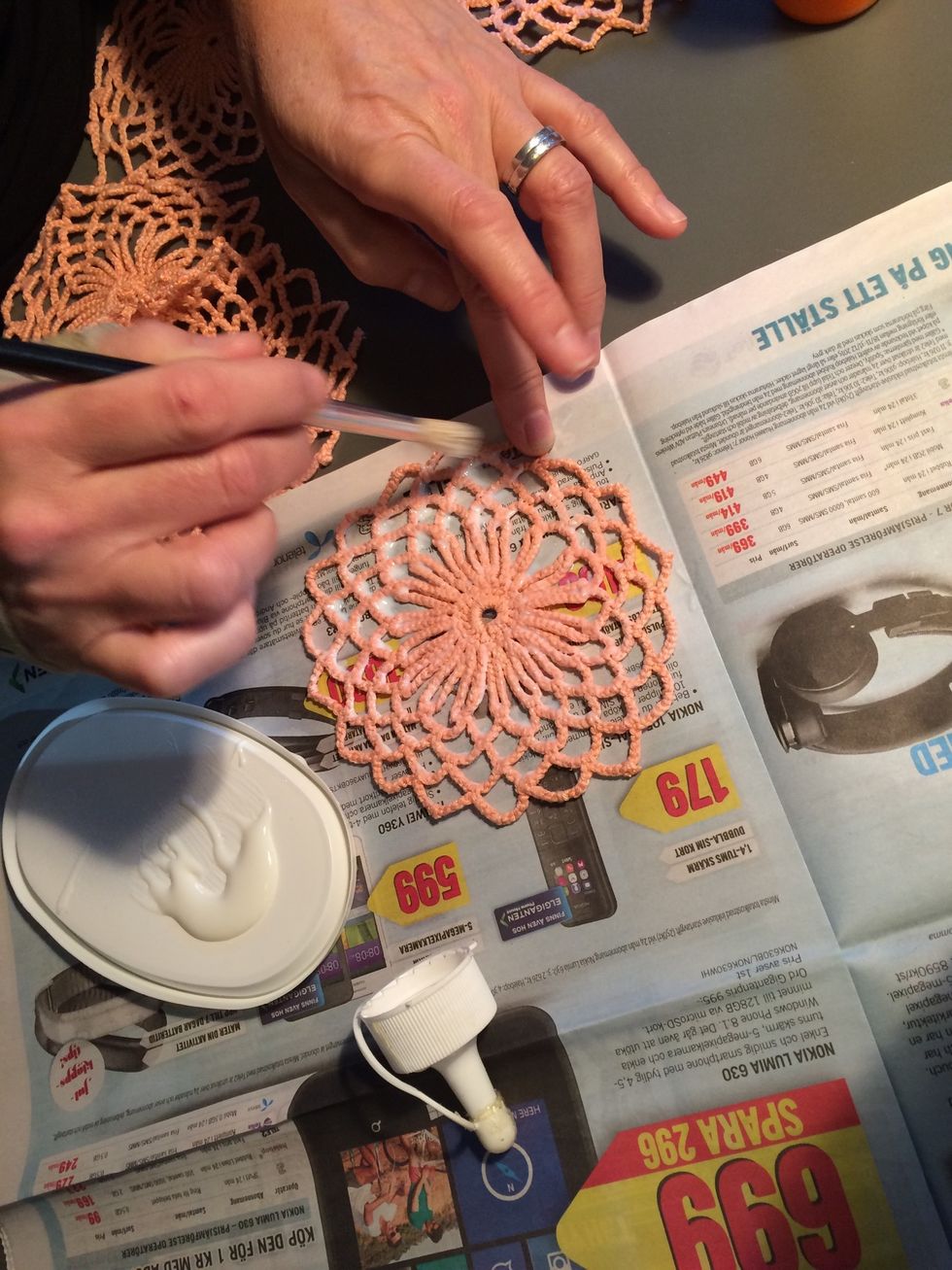 L\u00e4gg virkningen p\u00e5 ett tidningspapper och pensla p\u00e5 limmet.