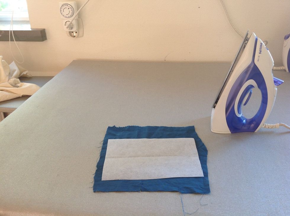 L\u00e4gg vlieselinet med den blanka sidan mot avigsidan (baksidan) p\u00e5 tyget. Var noga s\u00e5 att det hamnar p\u00e5 r\u00e4tt st\u00e4lle.