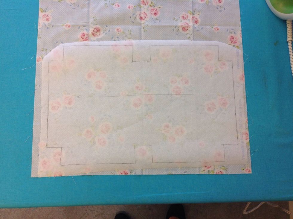 L\u00e4gg vliselinet p\u00e5 tygets avigsida med limmet ned\u00e5t. T\u00e4nk p\u00e5 tr\u00e5driktningen. Pilen p\u00e5 m\u00f6nstret ska f\u00f6lja tr\u00e5darna i tyget.