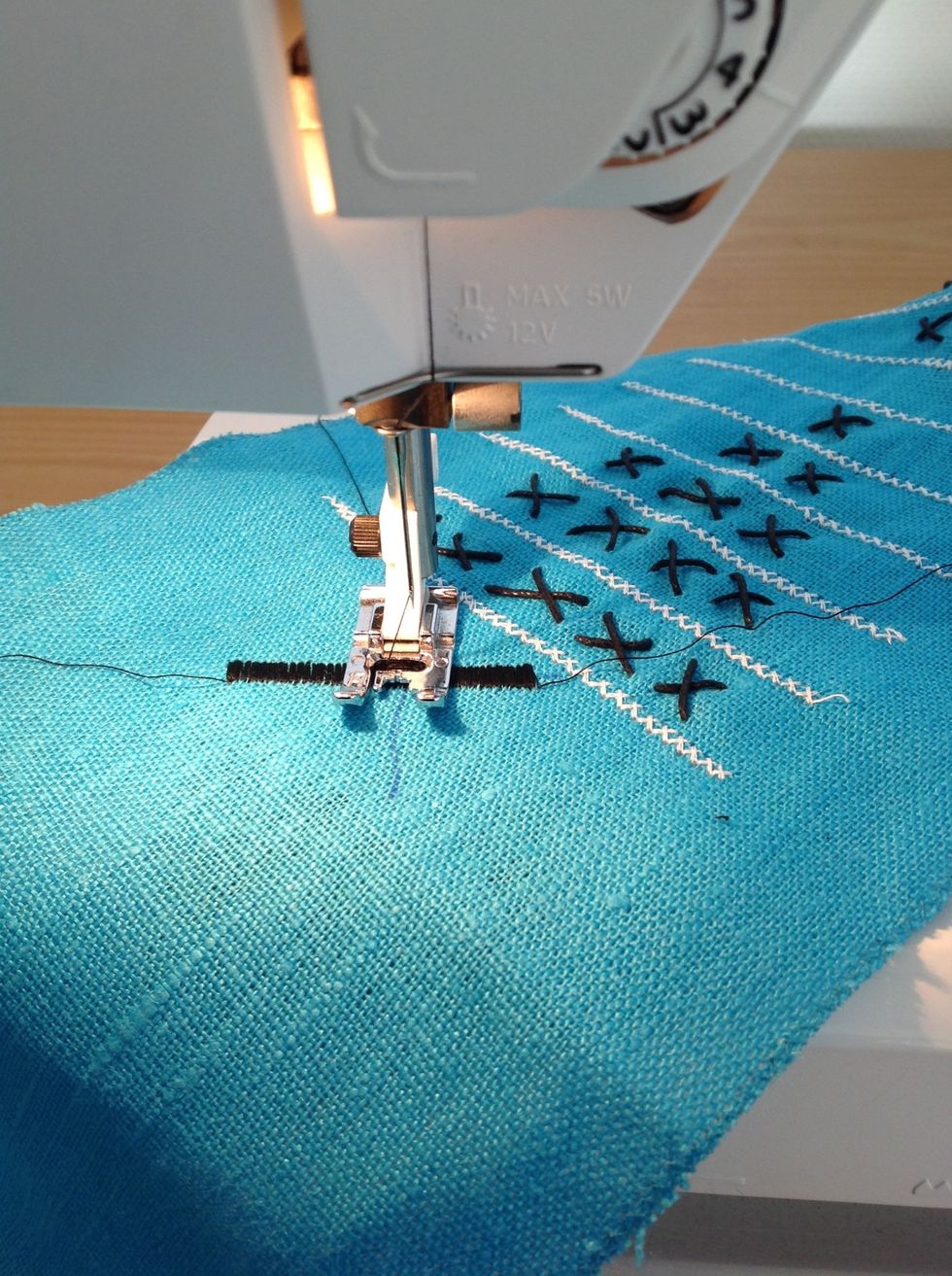 L\u00e4ngst upp och l\u00e4ngst ner ska det vara en symbol. H\u00e4r syr jag ett kryss med t\u00e4t sicksack.