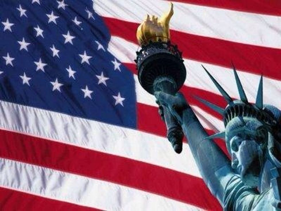 La bandera de Estados Unidos es de colores azul, rojo y blanco, la bandera de atr\u00e1s es la de Estados Unidos