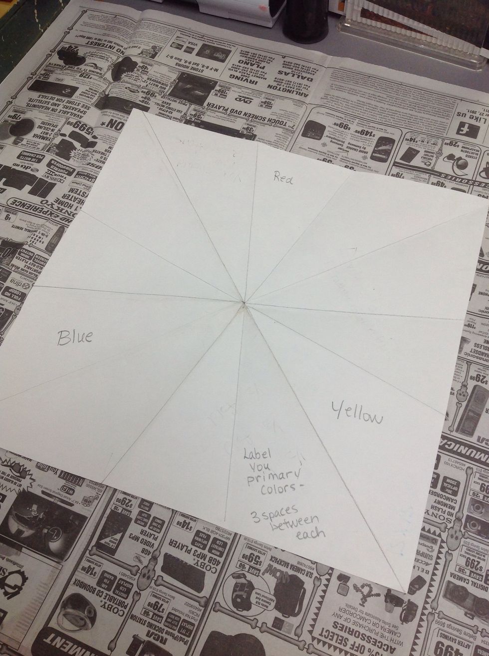 Label the primary colors (red, blue, and yellow) lightly in pencil. There should be 3 spaces between each.
