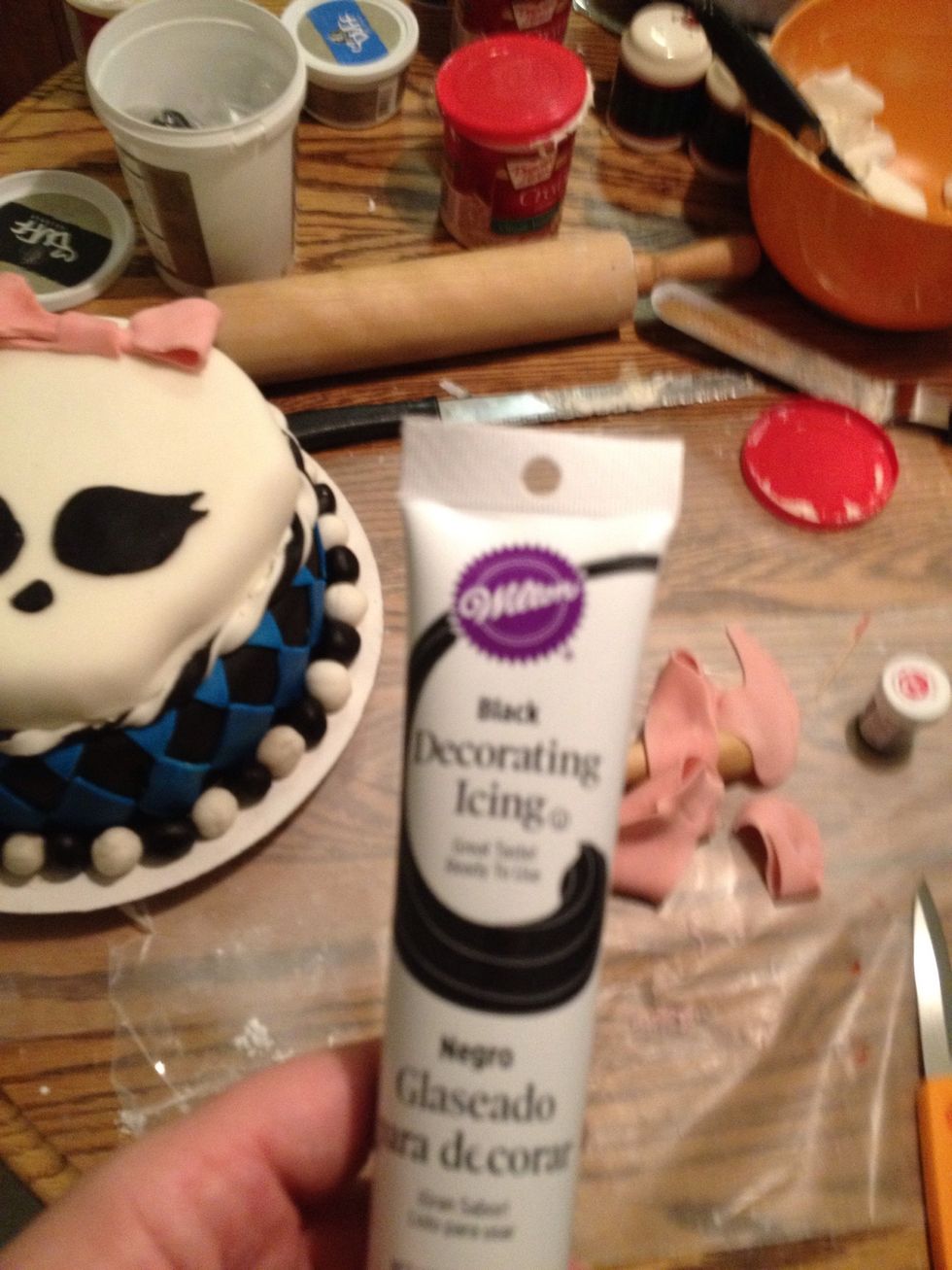Last, use some regular black frosting and a large tip to apply an outline to the Skullette layer.