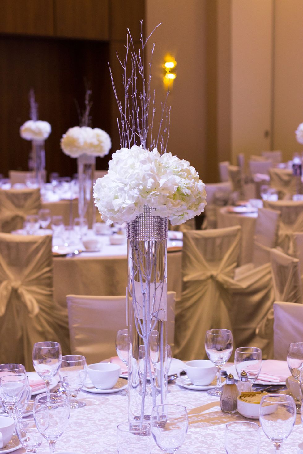 Lastly, cut stems off of the hydrangeas (make sure stems cannot be seen below the rhinestone trim) and put them in the vase. The branches should be in the middle with the hydrangeas surrounding them.