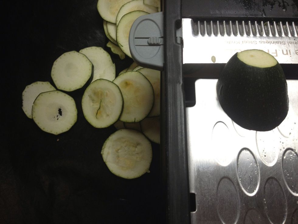 Lavez les courgettes et coupez les, sans les \u00e9plucher, en rondelles de 2 mm d'\u00e9paisseur (de pr\u00e9f\u00e9rence \u00e0 la mandoline).