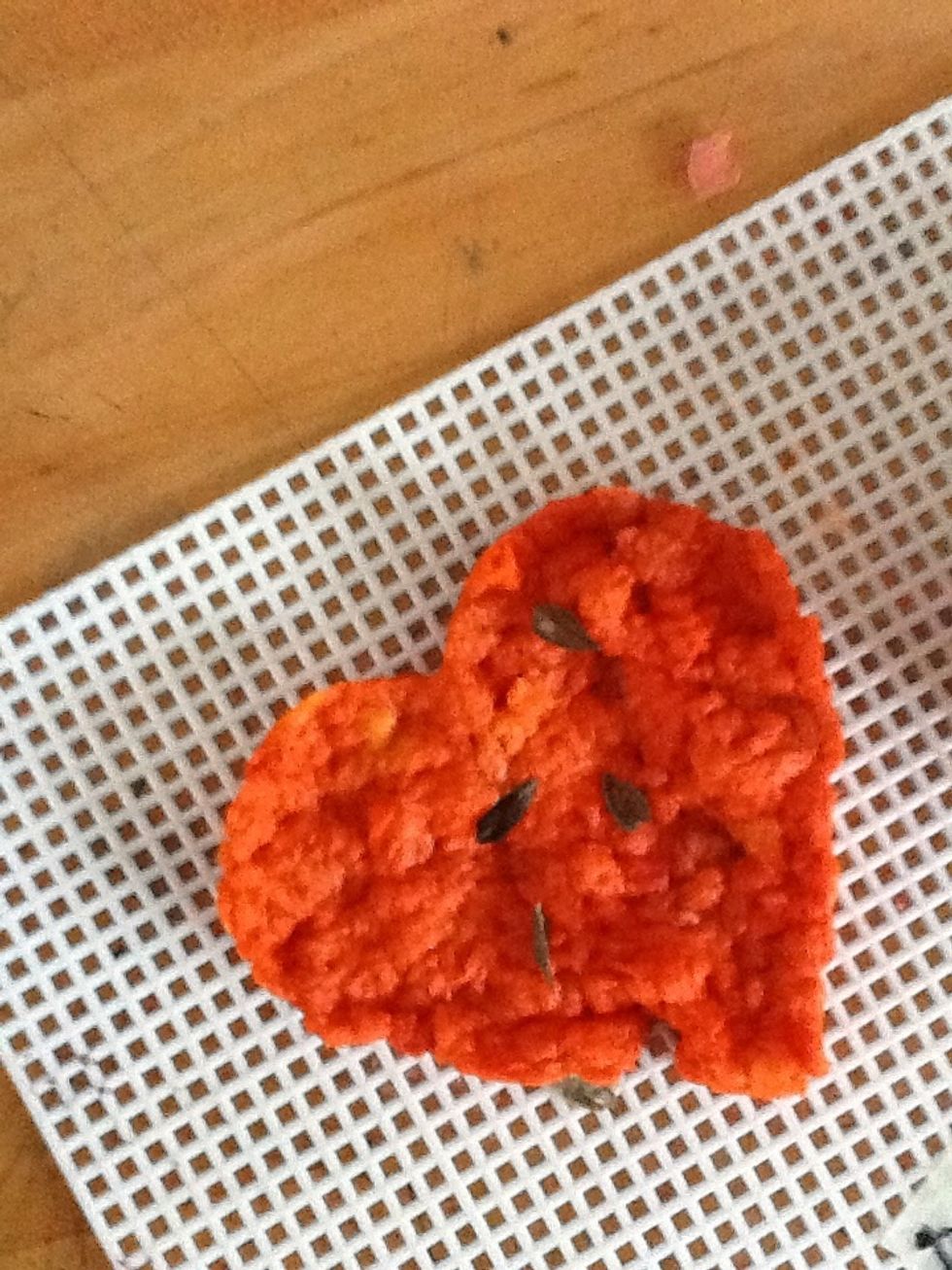 Lay 3-4 seeds on the shape and press a little more pulp over them to help secure them.