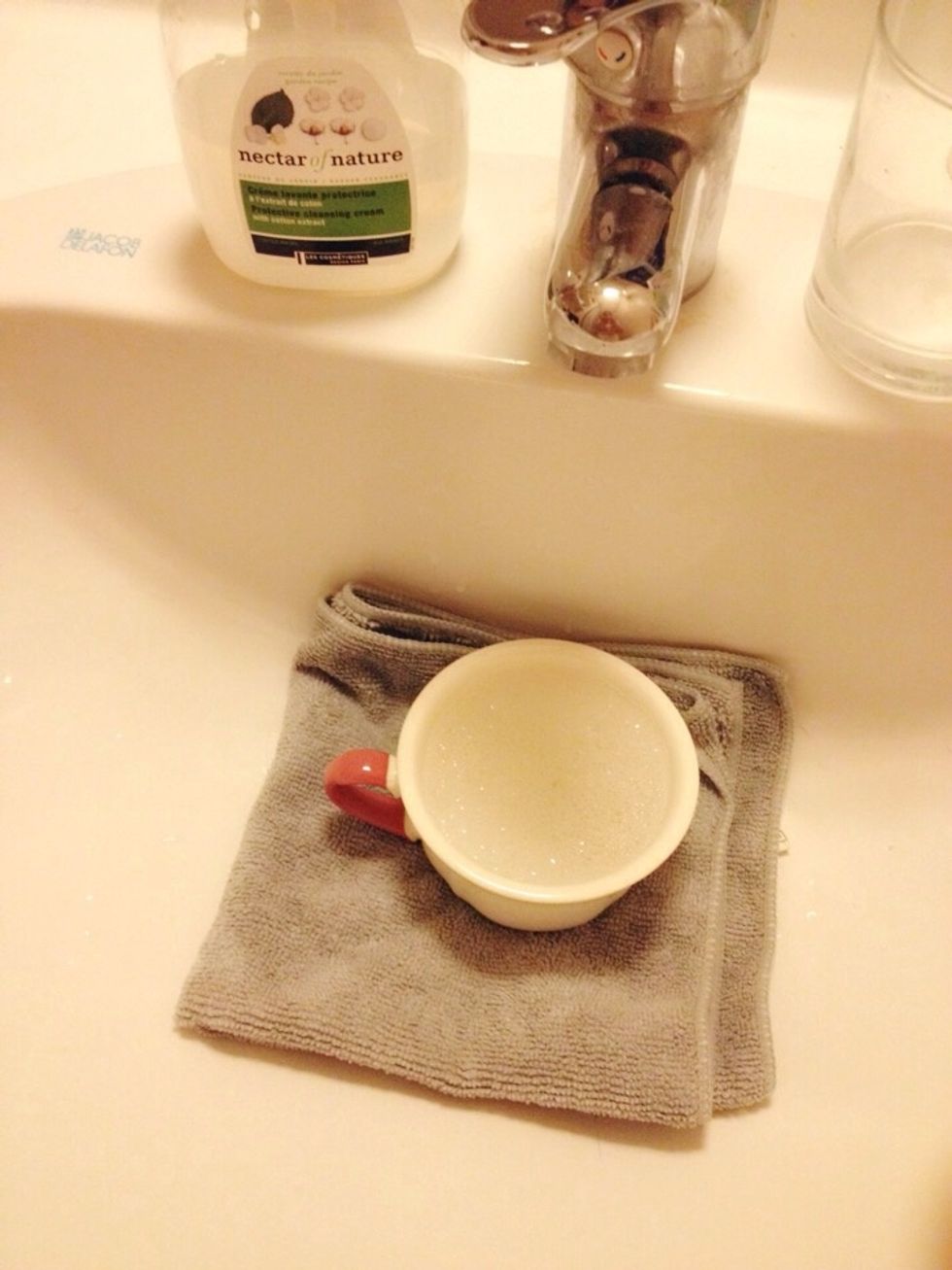 Lay a cloth over your sink in case anything falls in! Add soap, warm water and excess lemon juice into the cup and let it soak a while (5mins or so)
