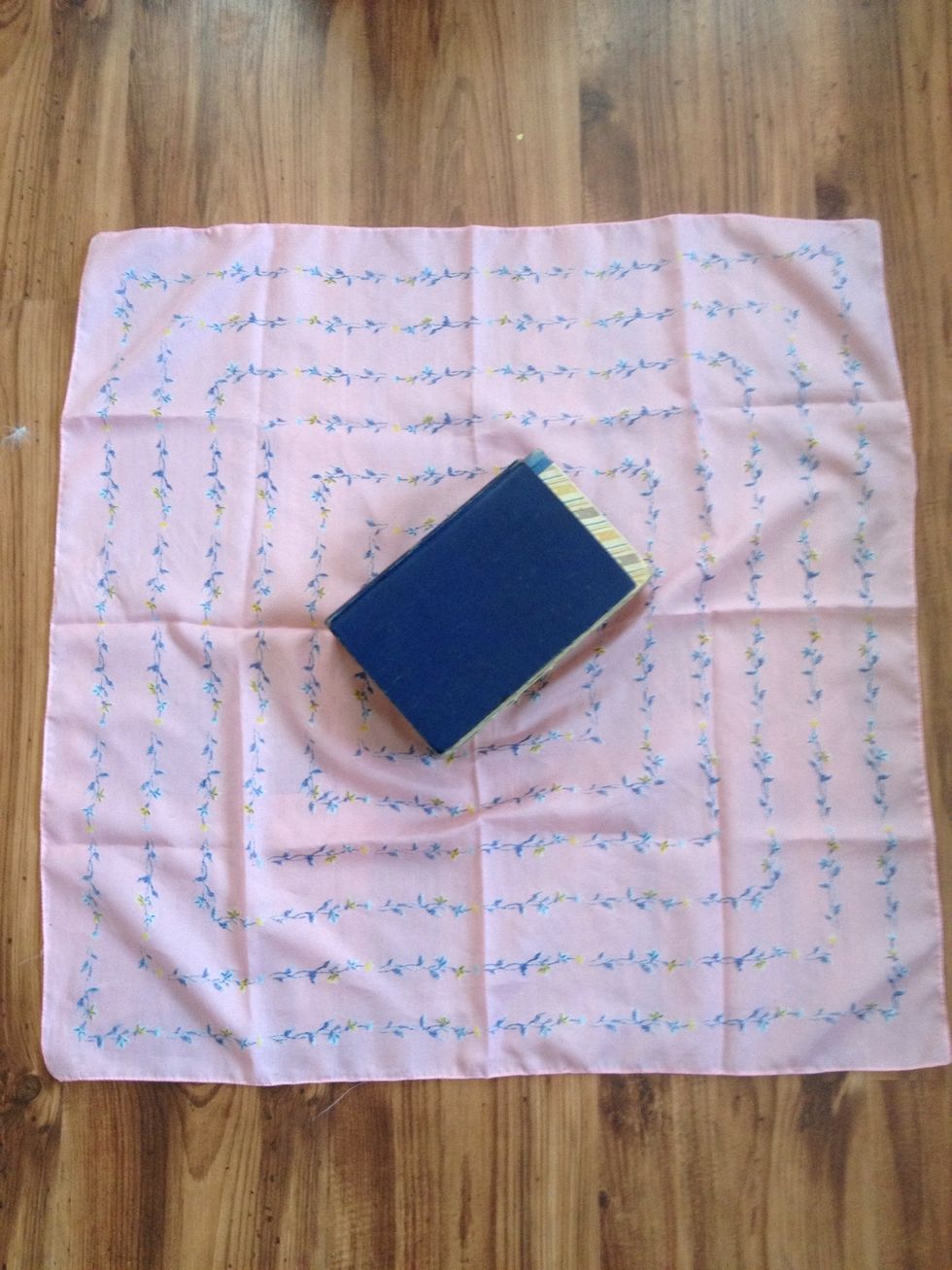 Lay books in center of scarf, pointing to the corner.