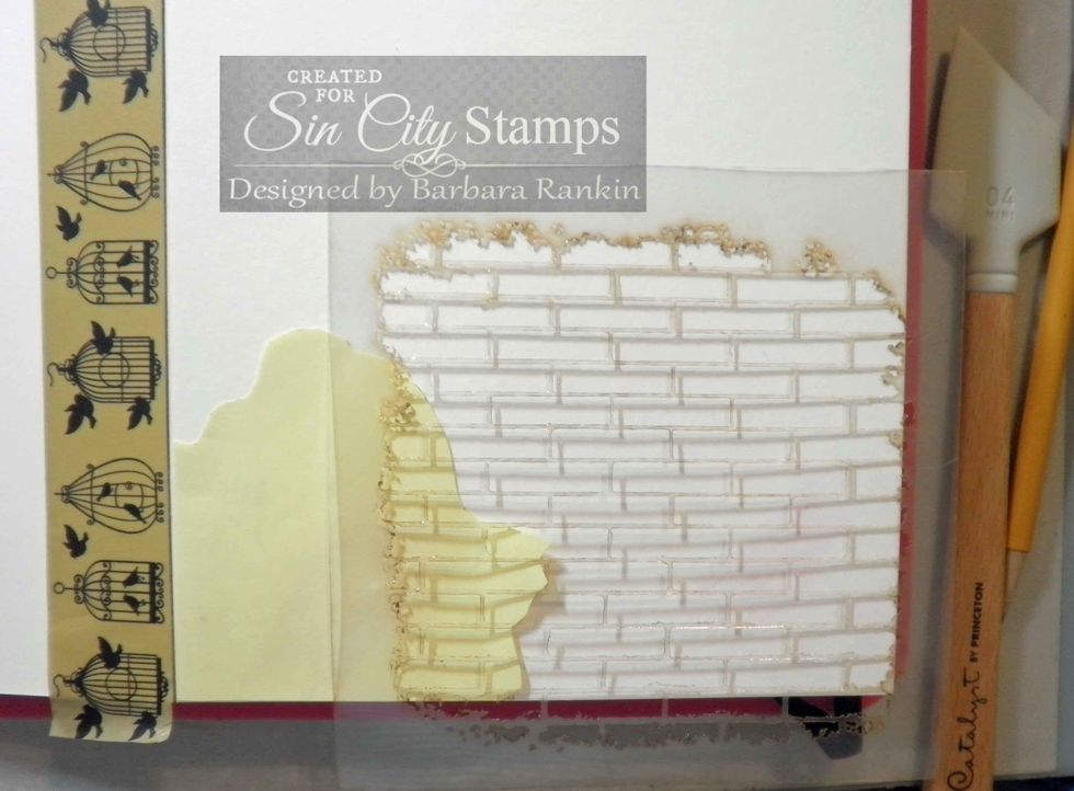 Lay brick stencil over rose mask and apply light molding paste through bricks with spatula.