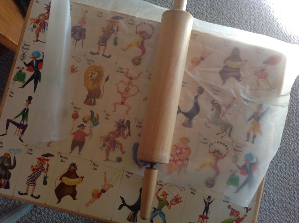Lay down a large piece of wax paper, and use a rolling pin to roll back and forth over the cards/paper you have glued down. You want to have a tight seal, and no air bubbles.