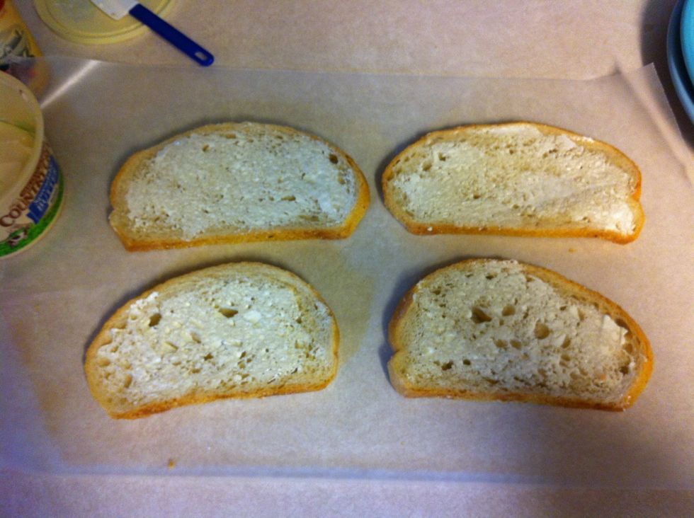 Lay down wax paper on the counter. Butter one side of each bread slice then flip over bread.