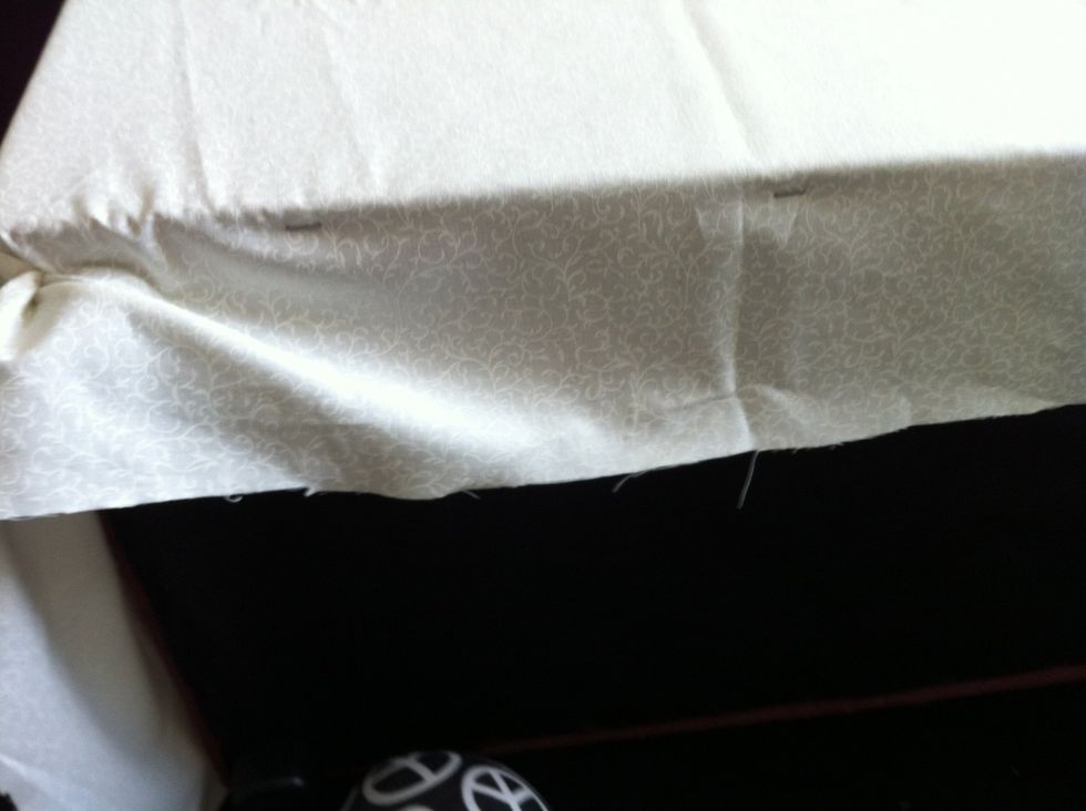Lay material over next area stapling at top under the lid an pull tight under the the ottoman and staple