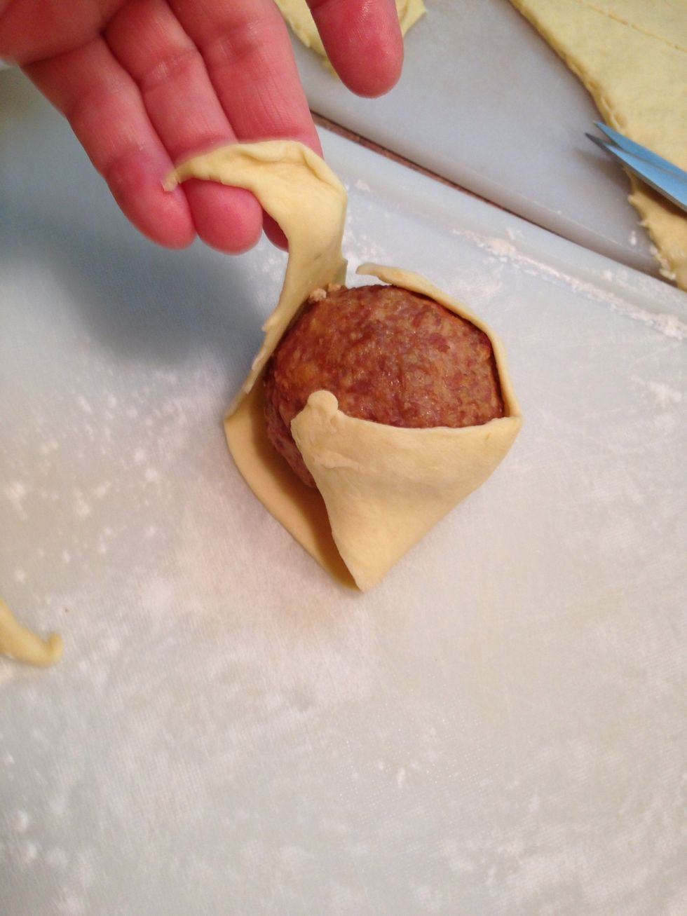 Lay meat/egg ball onto triangle and fold in corners as shown...