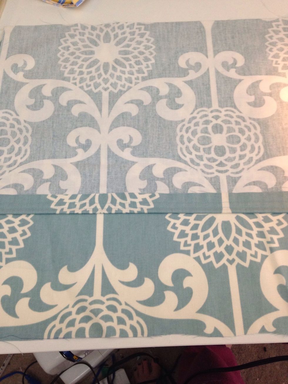 Lay one of your hemmed pieces on top, right side to right side and hemmed side towards the center.