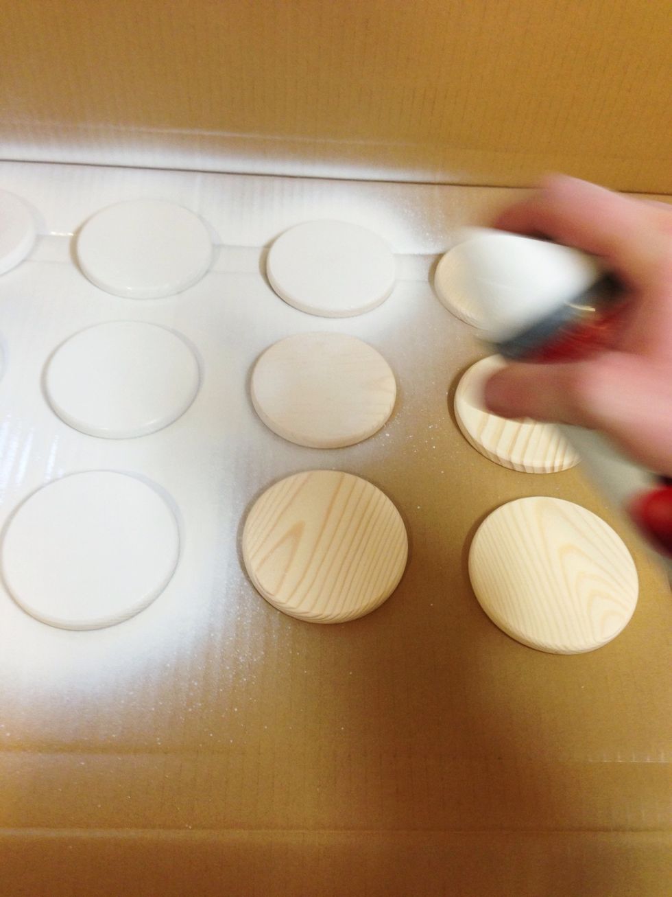 Lay out the coasters on a large piece of cardboard and start painting them.