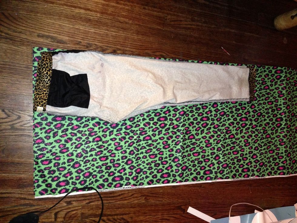 Lay out with the front of the legs along the fold and the tush towards the center of the fabric.