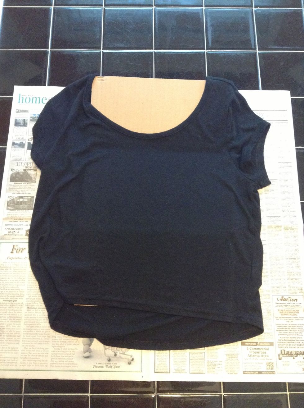 lay out your black shirt on newspaper and put a price of cardboard inside. this is important so the paint and bleach doesn't run through