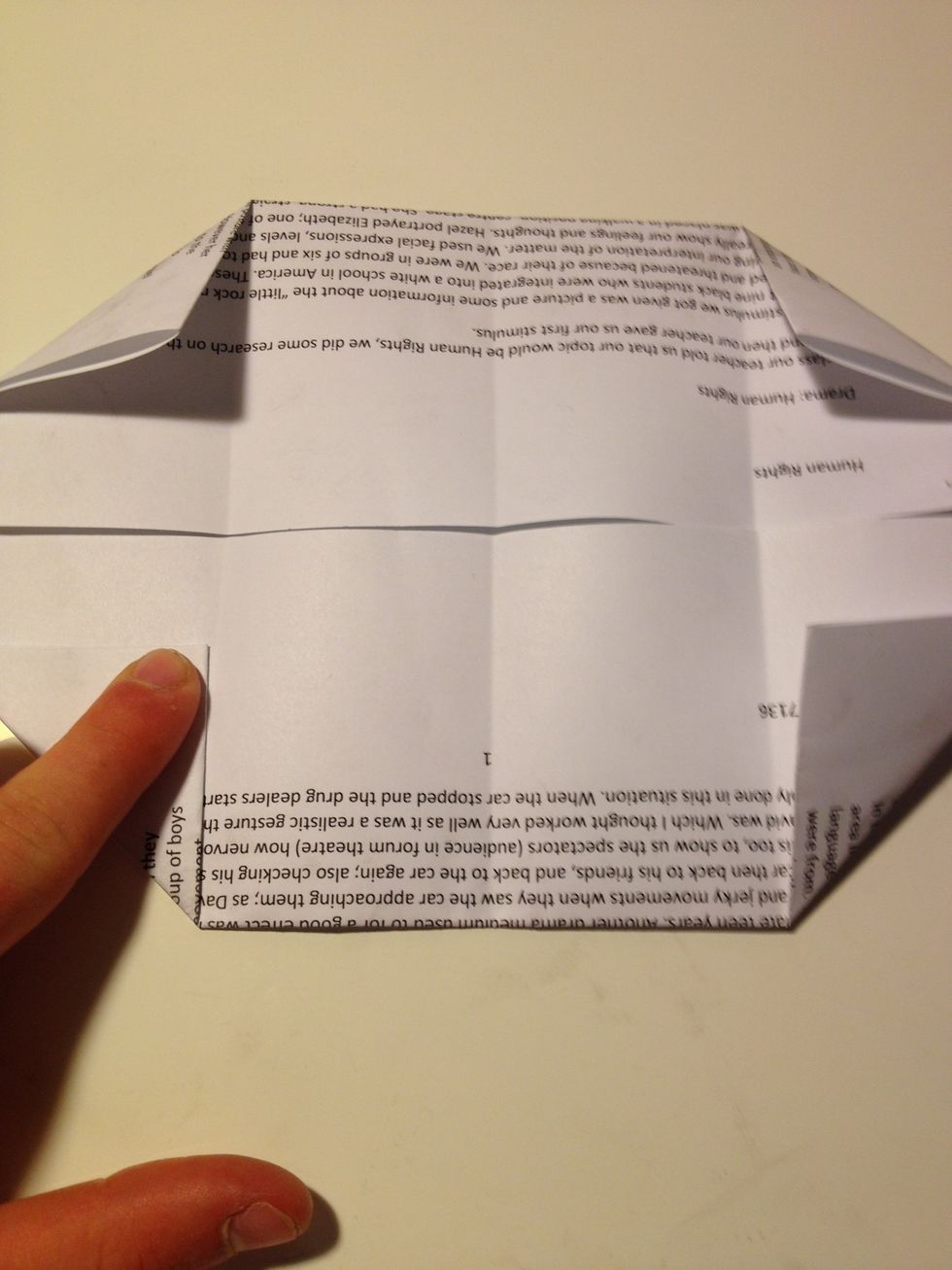 Lay paper out flat and fold each corner inwards so the edge of the corner lines up with the crease line as showed