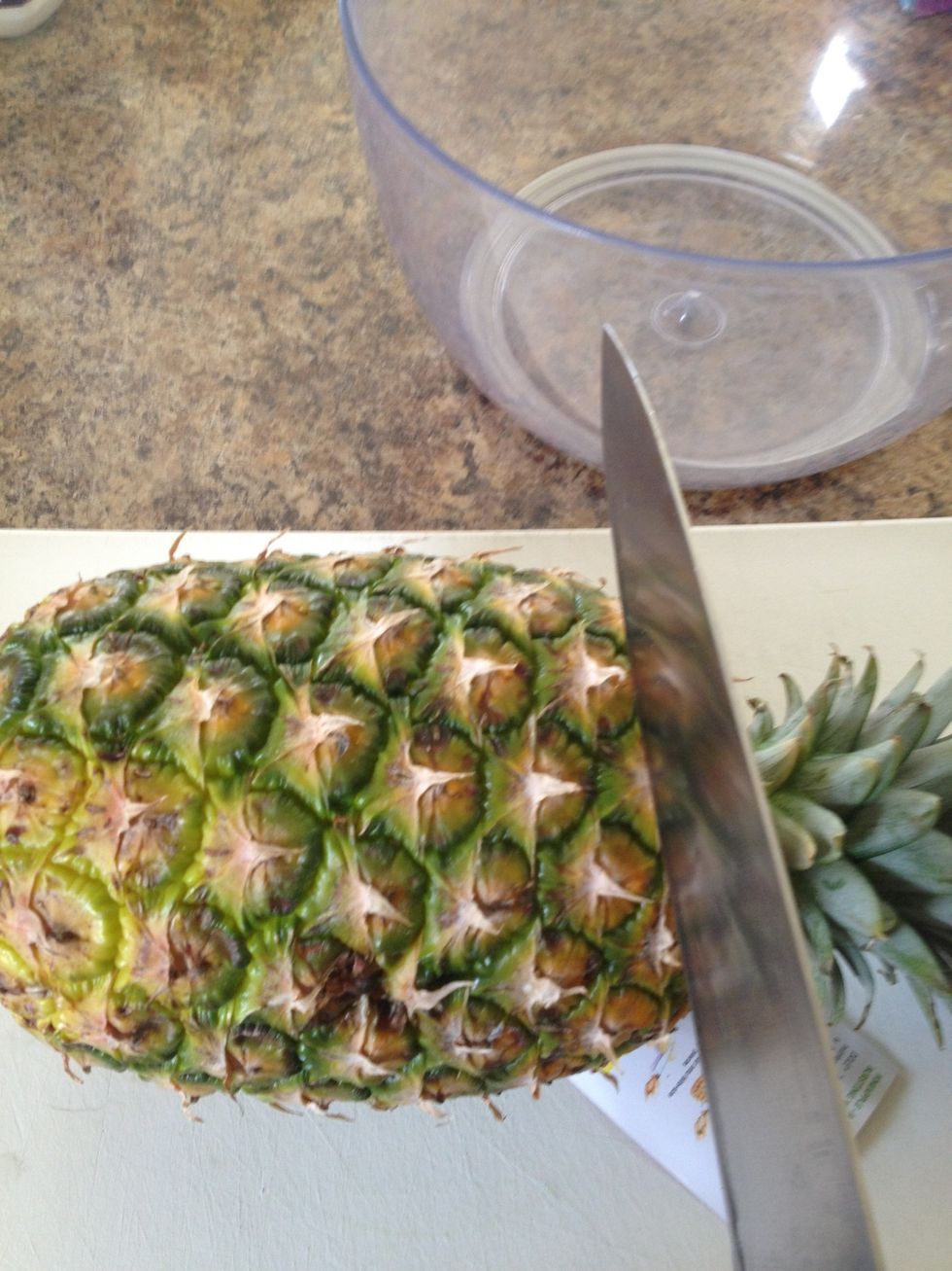 Lay pineapple on cutting board and cut off the top