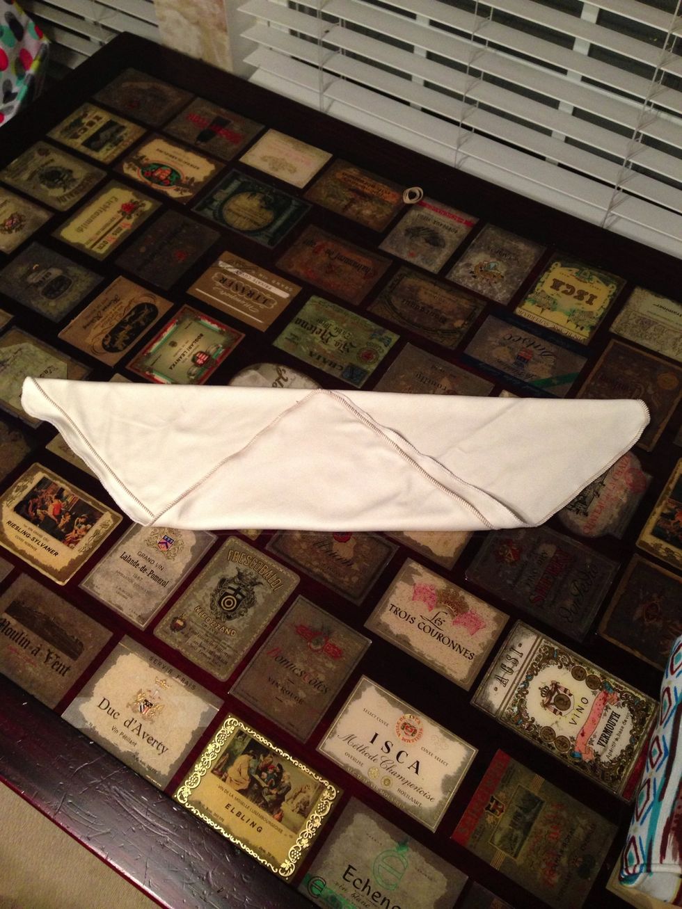 Lay the baby down on the flat with the top (flat) section right on baby's lower back. Bring the bottom point up between baby's legs, to create a snug fit. Fold the top point down again if needed.