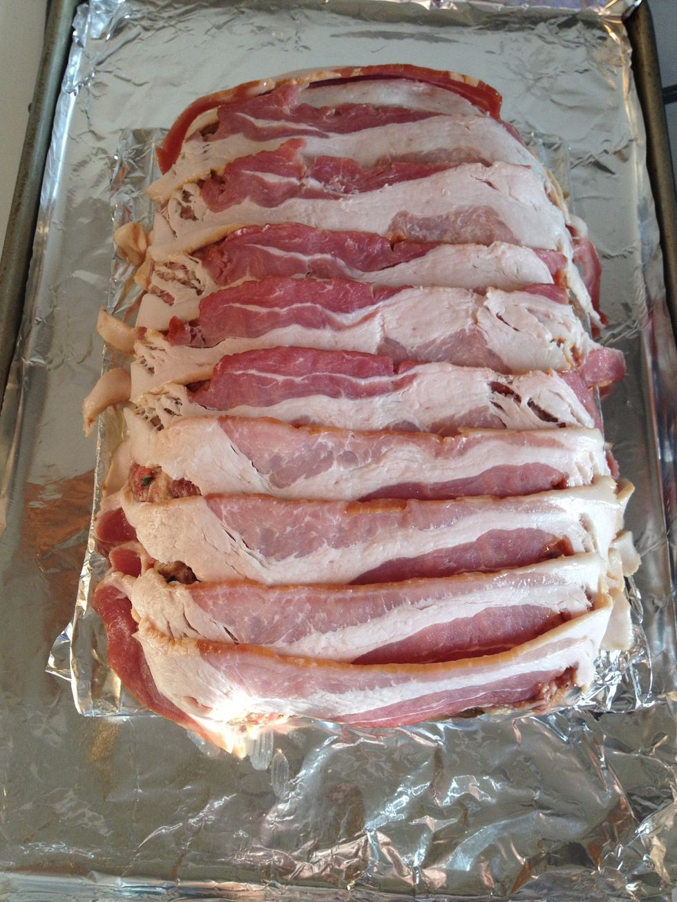 Lay the bacon slices over the top, tucking them underneath the meatloaf to help give it some support.