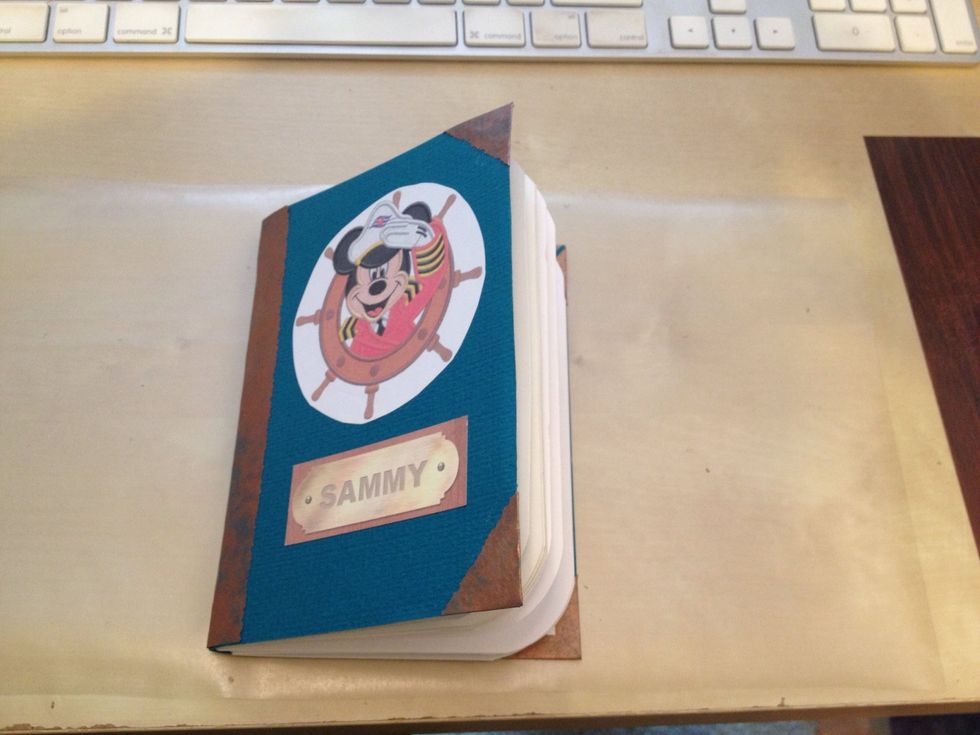 Lay the book on the sticky side, making sure the spine sits on the center of the con-tac paper.