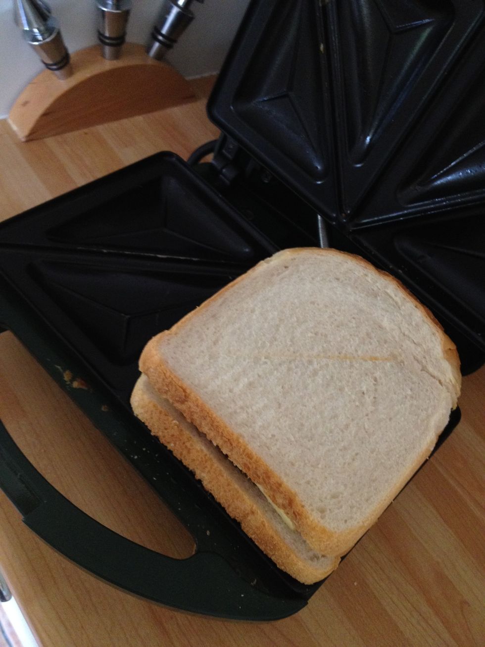 Lay the bread with the food on the toasted sandwich make first, then add the top slice covering it up. Close the sandwich toaster and wait for it to toast and melt the cheese.