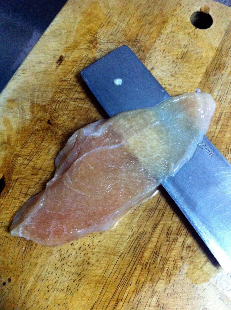 Lay the chicken breast flat on the cutting board and slice across to you get flat pieces around 1/8 inch thick. A little thicker is okay. I find it easier to slice if the meat is semi frozen.