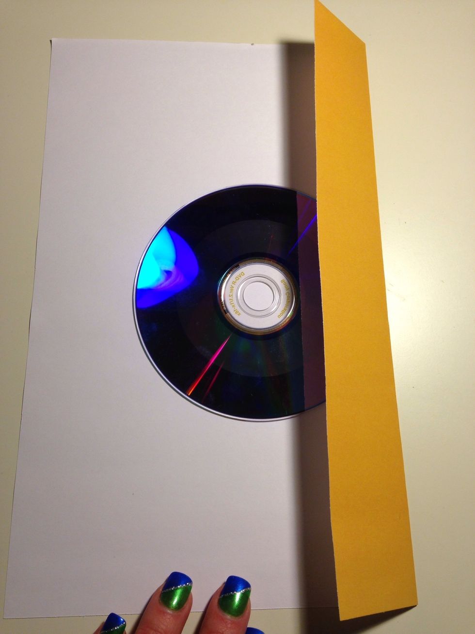 Lay the disc in the center of the paper. Fold one side in on the disc.