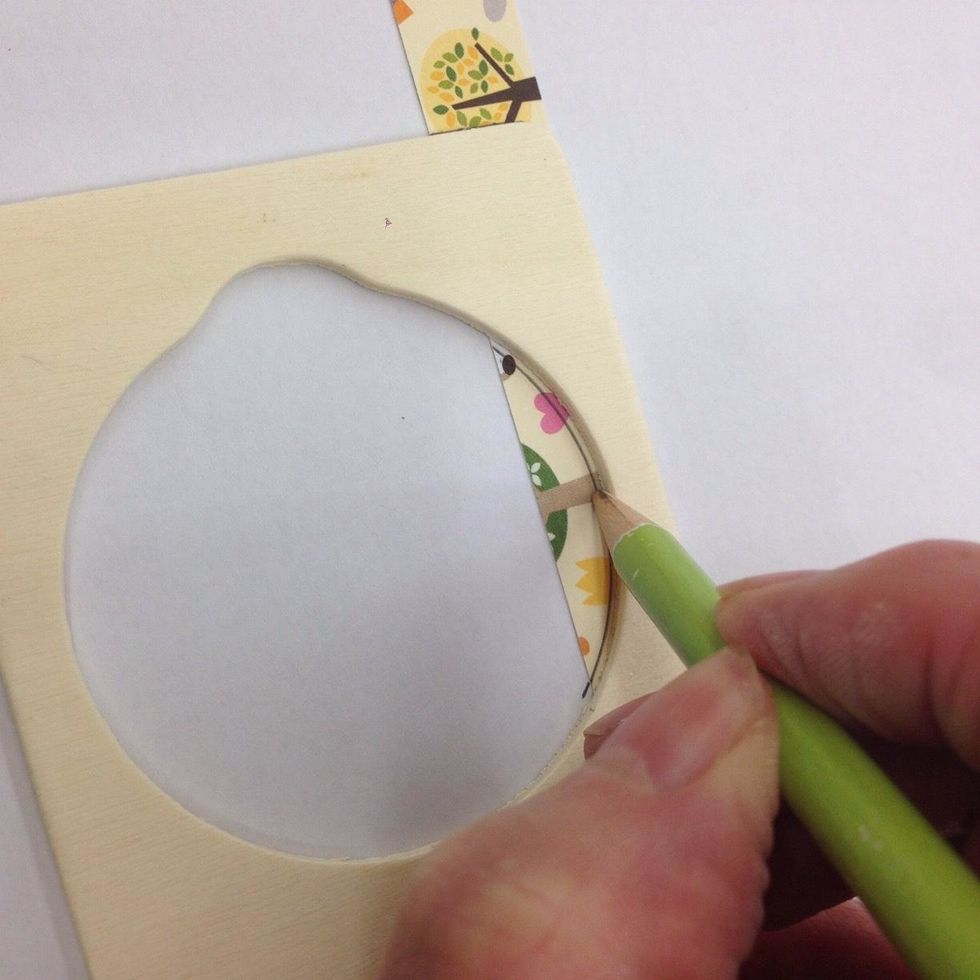Lay the door hanger on the BACK side of the green paper strip. Trace the parts that will need to be cut away: top and bottom edges and the curved area as shown.