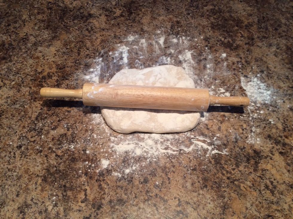 Lay the dough ball in the flour and flip it over so you get flour on both sides. Get a rolling pin and make life easy, flour that up too!