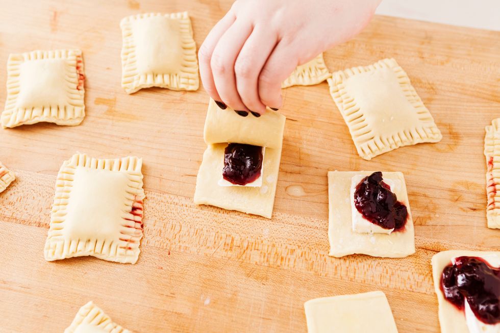 Lay the egg wash sheets on top of your brie and cherry jam rectangles.