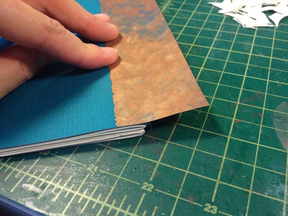 Lay the fancy edge down on the front cover, leaving a flap toward the spine.