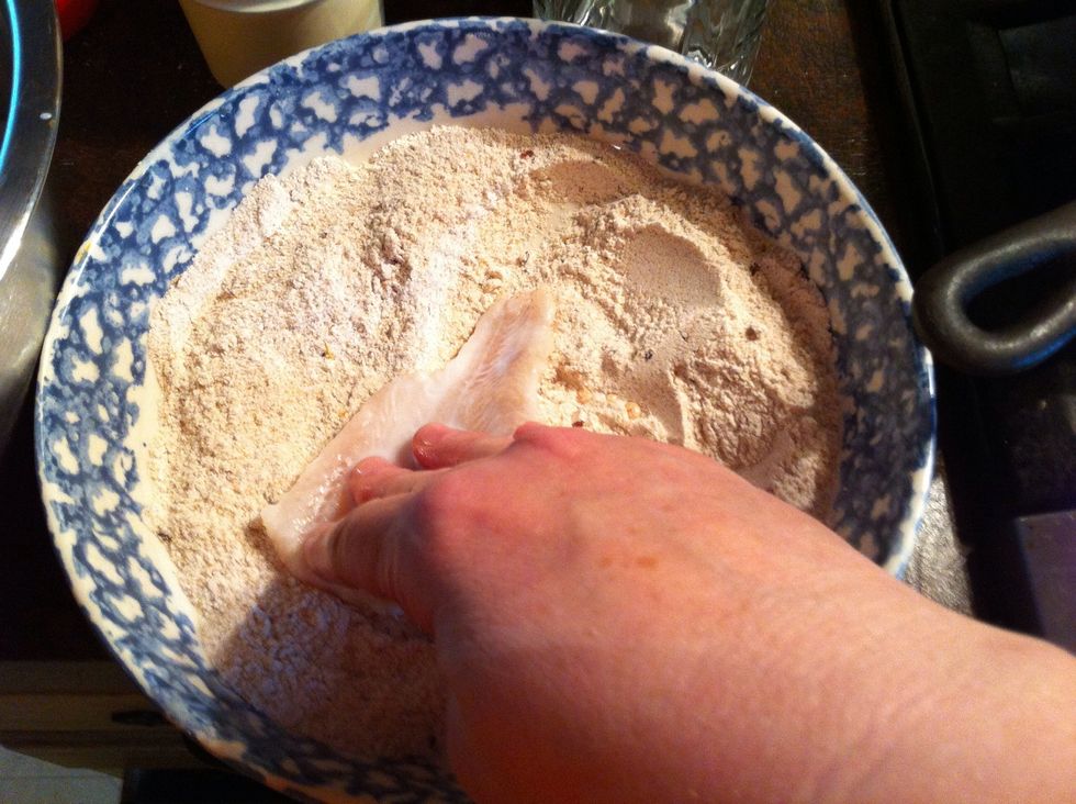 Lay the fish down to coat one side.