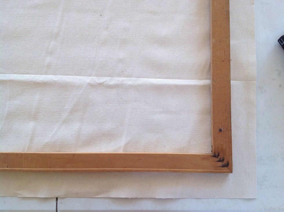 Lay the frame on your canvas, about 2" from two adjacent edges of the canvas.