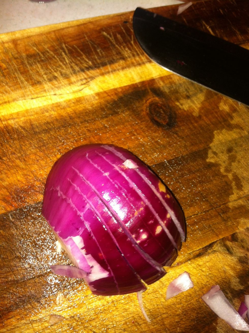 Lay the half onion on its side and make slices in it like this. Don't cut the slices all the way threw the onion. (length wise) Leave a space at the back like above.