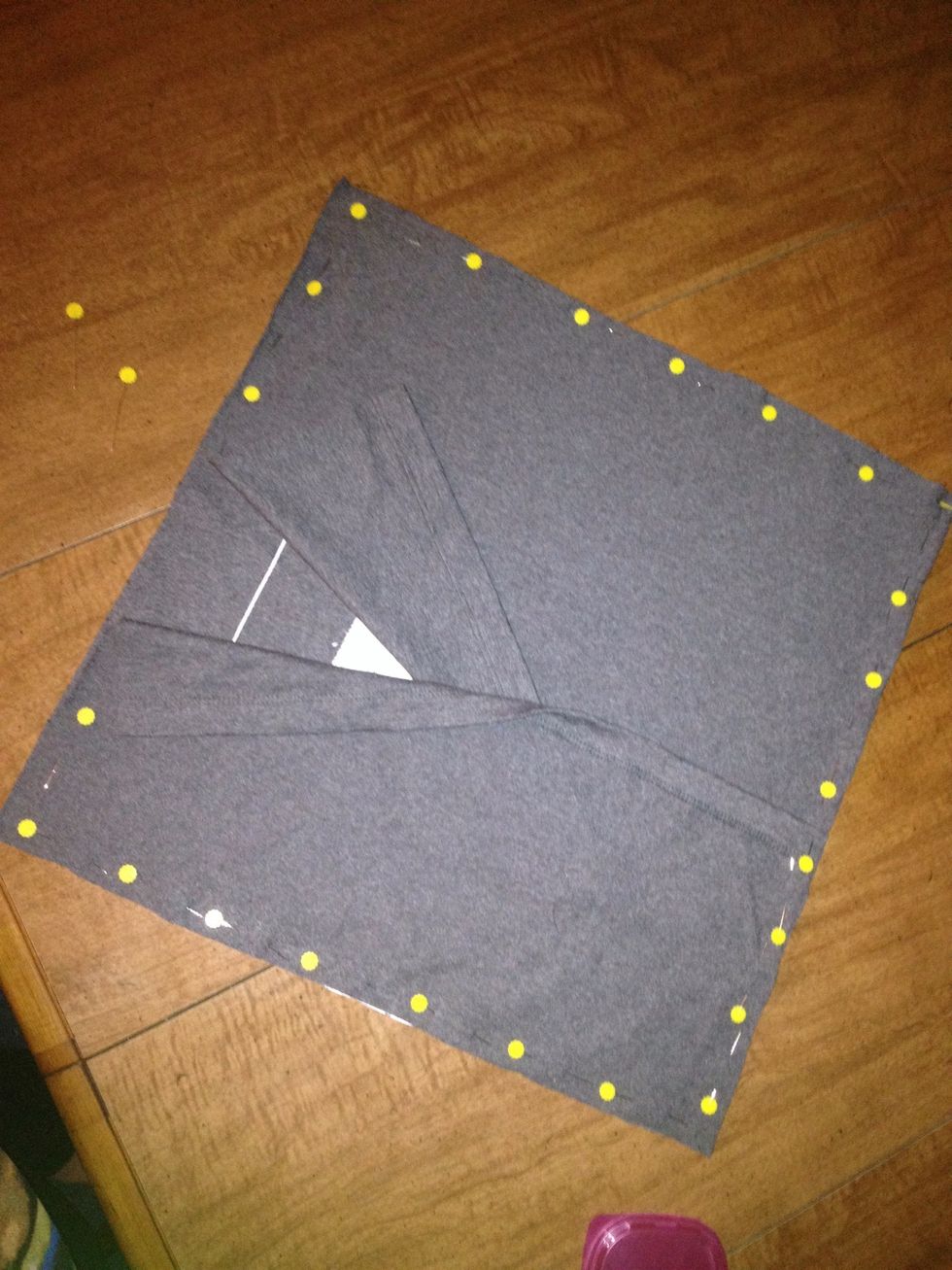 Lay the logo piece flat, face up. Lay one smaller piece on top of it, face down. Lay the last piece the same way, opposite the last one. The hems will overlap across the logo. Pin all the way around.