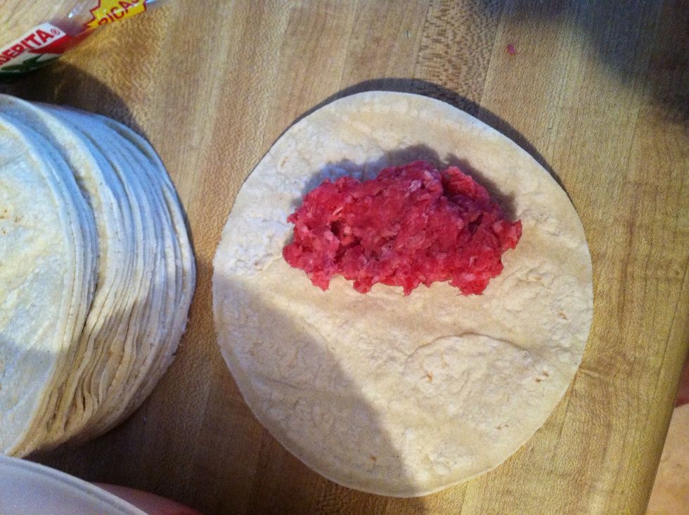 Lay the meat on the tortilla.