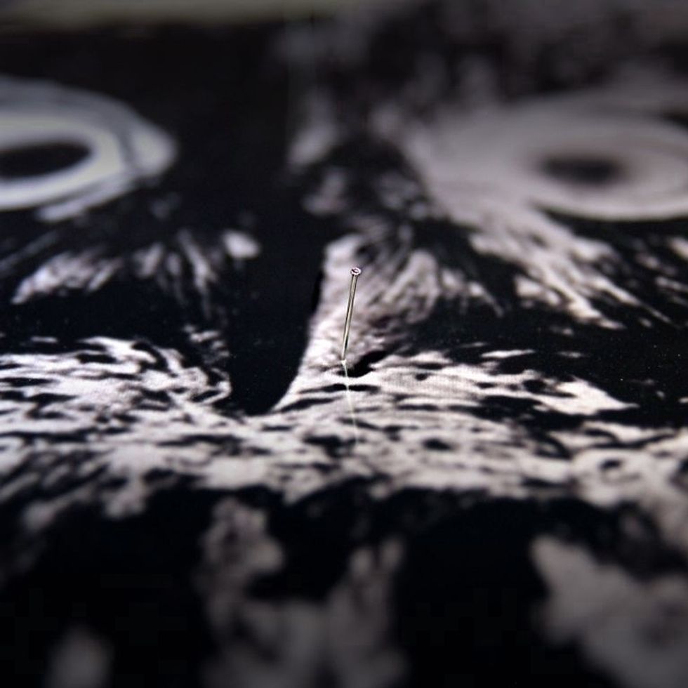 Lay the negative on top of the coated material, and secure in place with straight pins. Without pins, the heat from the light can cause your negative to curl.