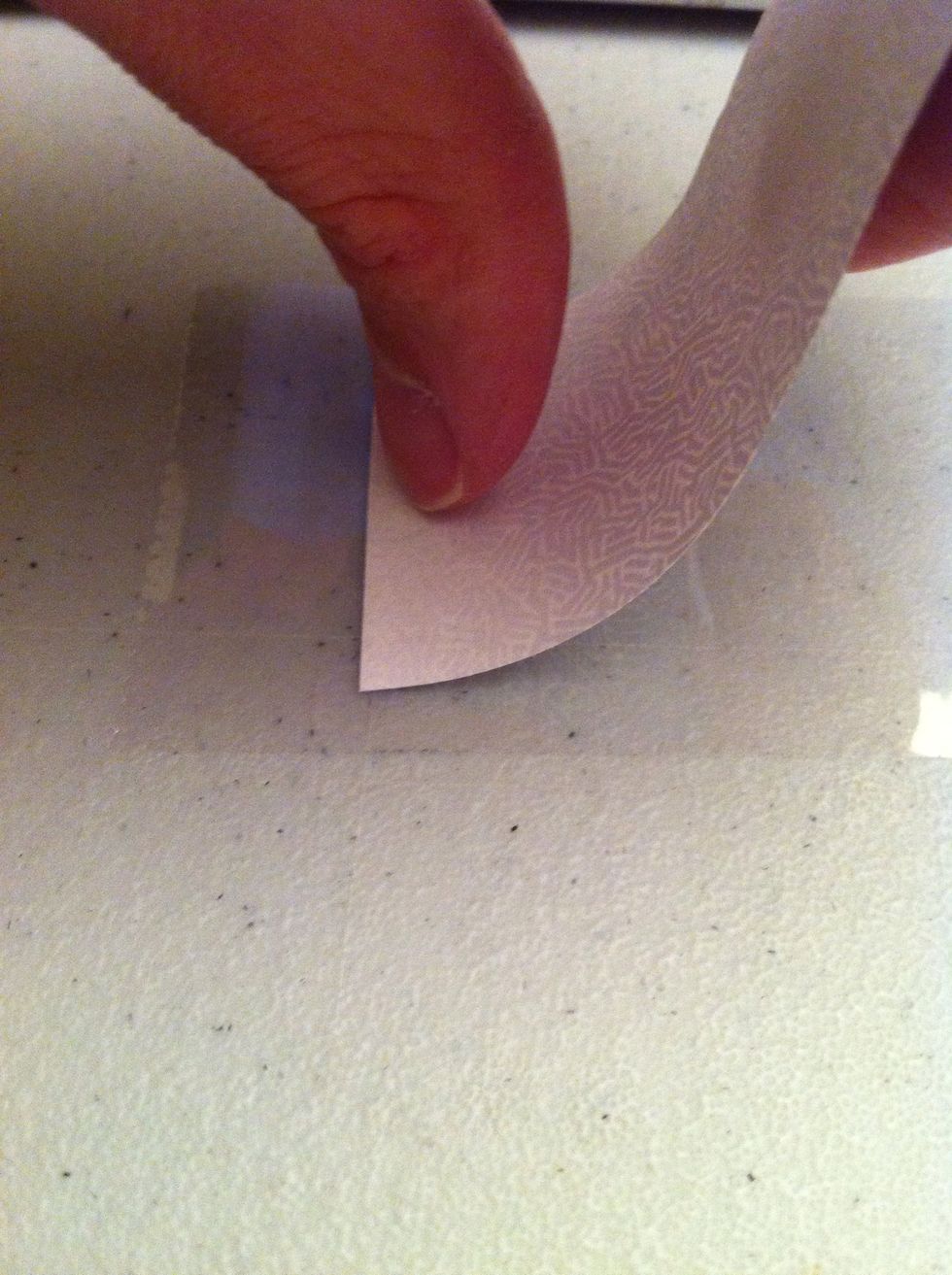 Lay the paper on top of it by beginning with one end and rolling the rest down.