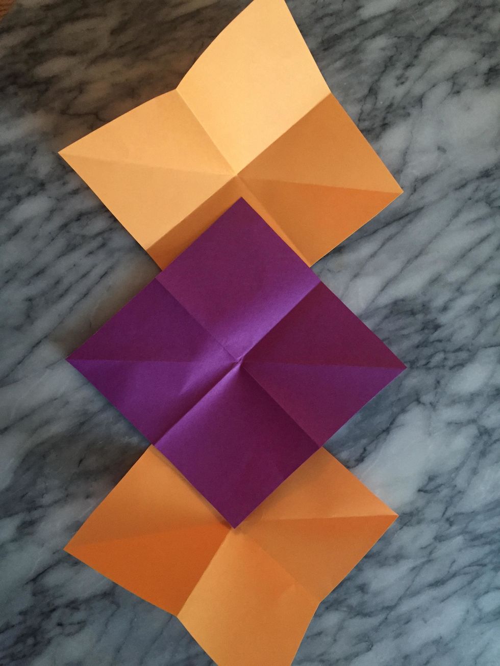 Lay the paper overlapping with diagonal folds  running in the same direction. The middle sheet is flipped over so the diagonal  folds upward, while the diagonals fold downward on the side sheets.