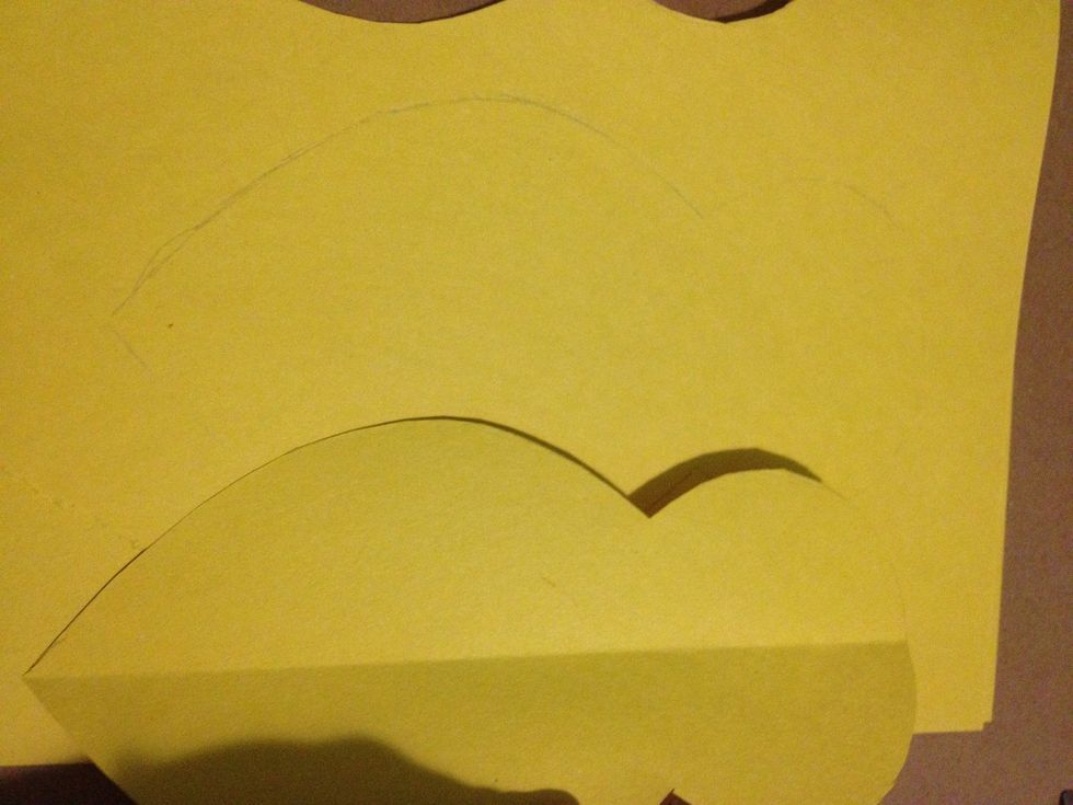 Lay the shape you just cut out on some more yellow paper and trace it.