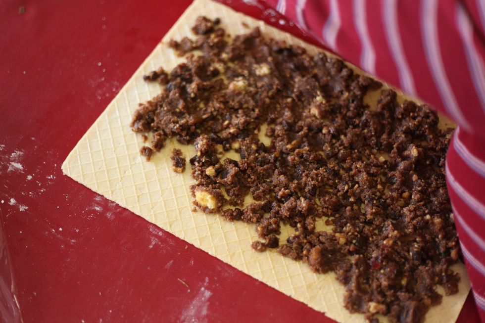 Lay the waffle sheet gently over the top of the icing sugar and cover it fully with your nut chocolate mix. And roll it up!! :)