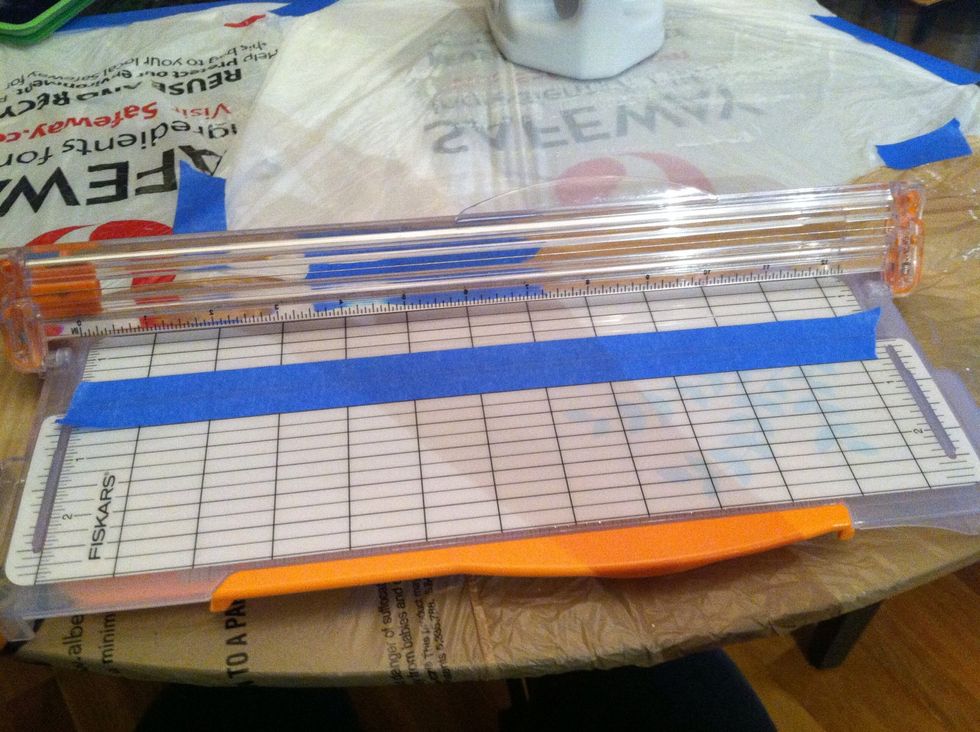 Lay your 1in painters tape on the paper cutter so there is a 1/2in on either side of the cutting part