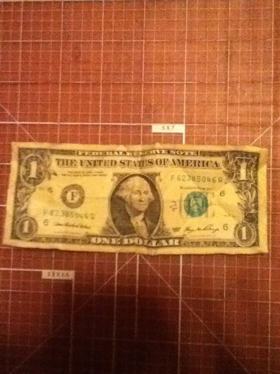 Lay your dollar out flat on a hard surface