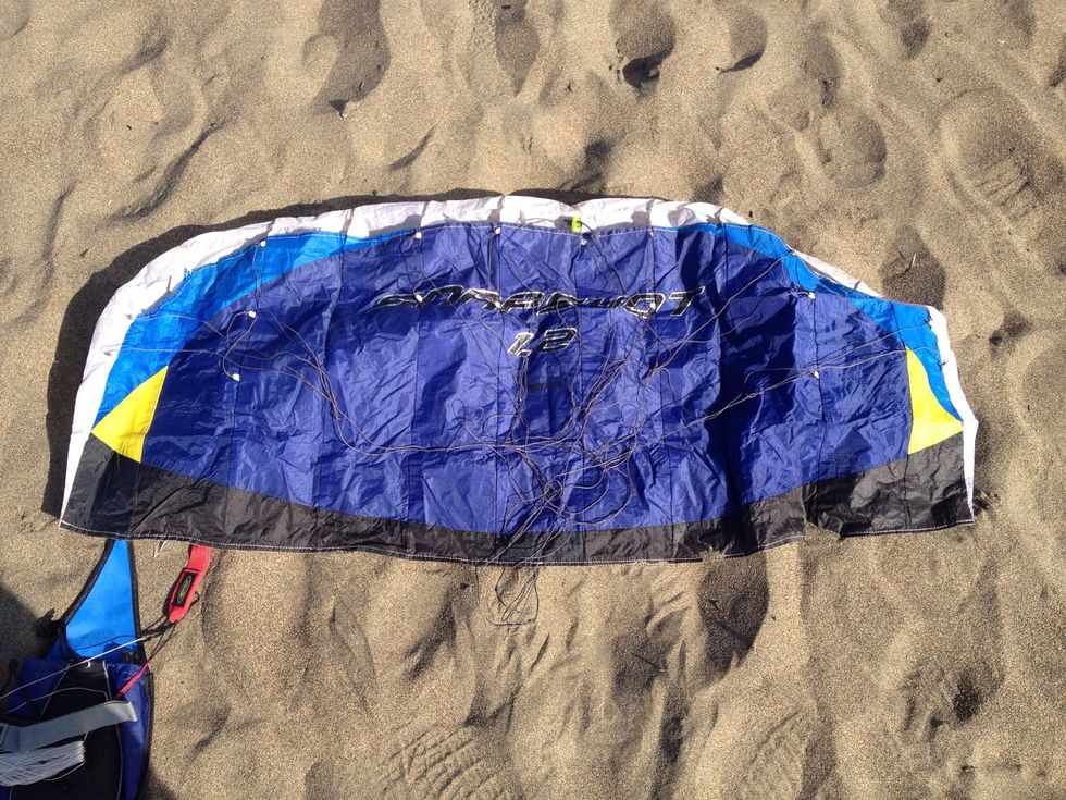 Lay your kite down. The bottom side should be facing up. Then you can attach the kite wires. I fly a simple kite by the brand Prism which has no hard parts which means I can crash and not worry!