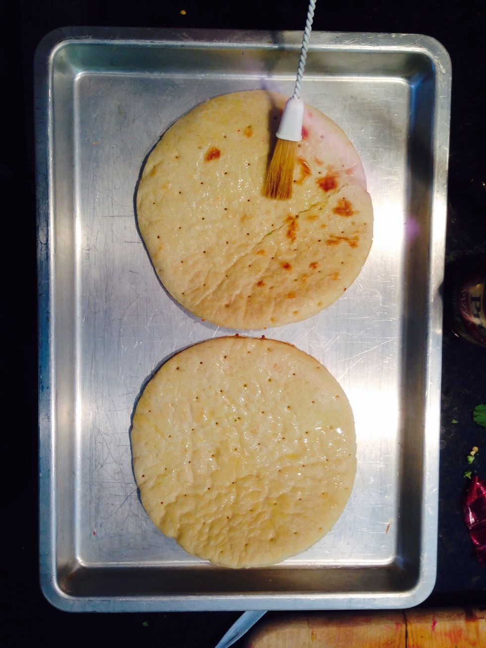 Lay your pre cooked base or dough, your choice, on your cookie sheet. Brush with Olive oil.