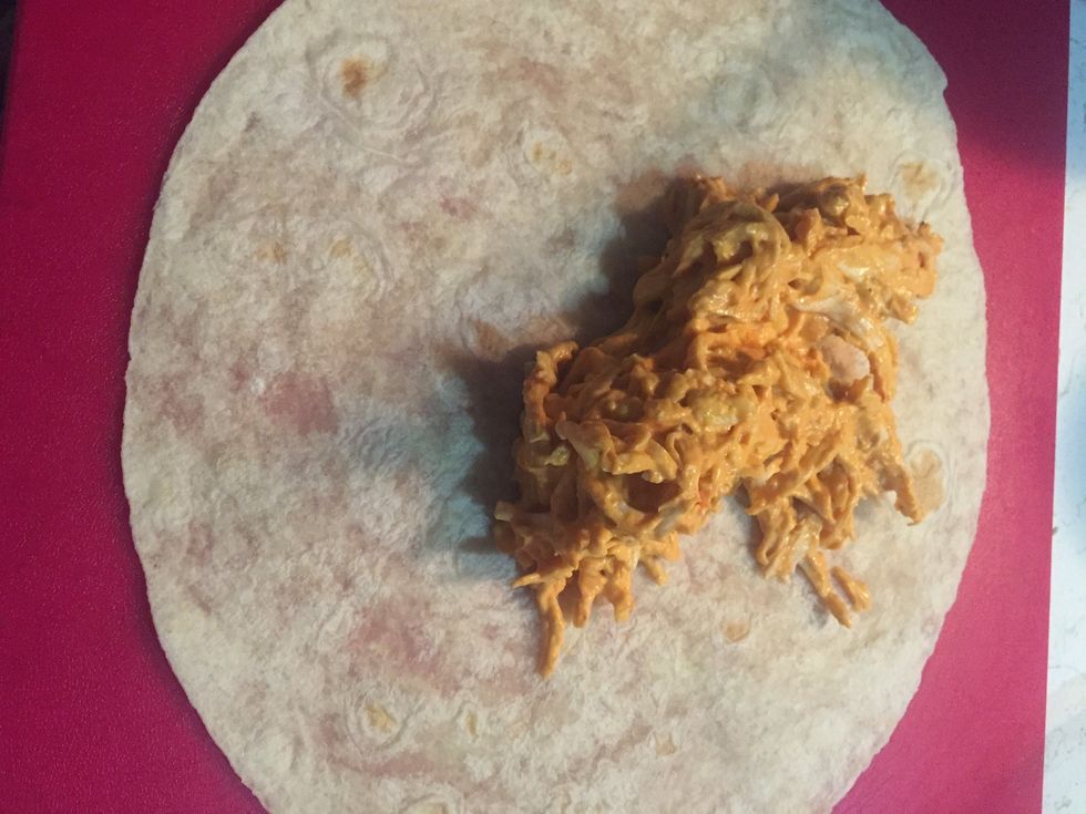 Lay your tortilla and spread the chicken mixture in it.