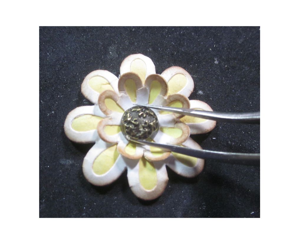Layer a large and a small flower together, glue down and then top off with a decorative metal brad from Graphic 45.  You can then brush the top of the brad with Distress Paint to blend.